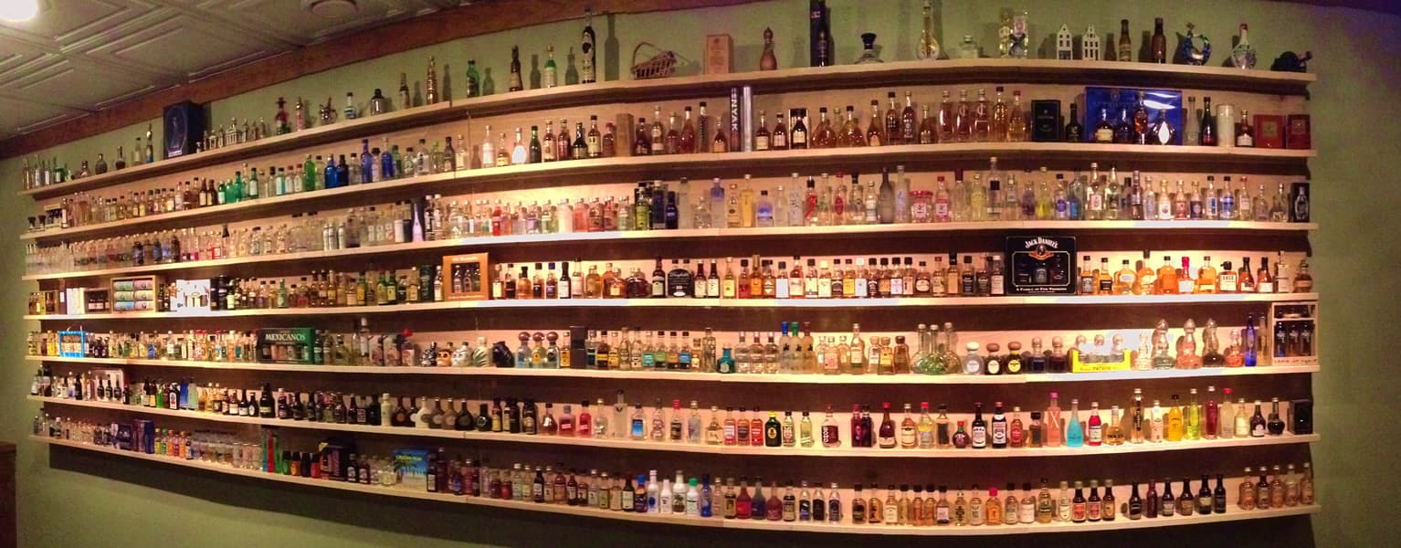 Panoramic view of basement shelving displaying the mini-bottle collection